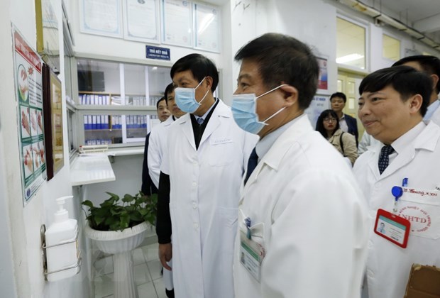 Thứ trưởng Đỗ Xuân Tuyên (trái) cùng đoàn công tác của Bộ Y tế kiểm tra công tác trực Tết và tặng quà cho một số bệnh nhân nặng điều trị tại bệnh viện Bệnh Nhiệt đới Trung ương. (Ảnh: Dương Ngọc/TTXVN)
