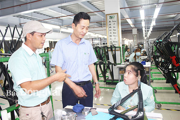 Đại diện doanh nghiệp và Công đoàn cơ sở Công ty TNHH Cự Thành (huyện Long Thành) trò chuyện, nắm bắt nguyện vọng người lao động tại xưởng sản xuất. Ảnh: L.Mai