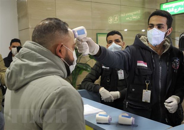 Nhân viên Cơ quan kiểm dịch Ai Cập kiểm tra thân nhiệt hành khách nhằm ngăn ngừa dịch viêm đường hô hấp cấp COVID-19 (nCoV) tại sân bay quốc tế Cairo. (Ảnh: AFP/TTXVN)