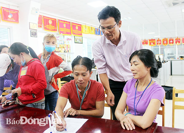 Cán bộ Công đoàn cơ sở Công ty TNHH Pousung Việt Nam (huyện Trảng Bom) hỗ trợ công nhân vay vốn cải thiện đời sống. Ảnh: L.Mai