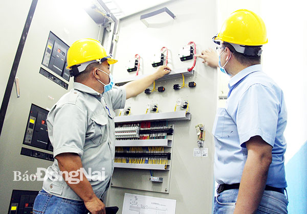 Cán bộ kỹ thuật của Công ty TNHH cao su Kenda Việt Nam (Khu công nghiệp Giang Điền, huyện Trảng Bom) kiểm tra vận hành hệ thống điện của công ty. Ảnh: Hải Quân