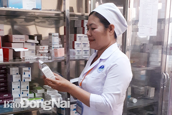 Dược sĩ Bùi Thị Thanh Huyền kiểm tra cơ số thuốc trong kho thuốc của Trung tâm y tế huyện Vĩnh Cửu