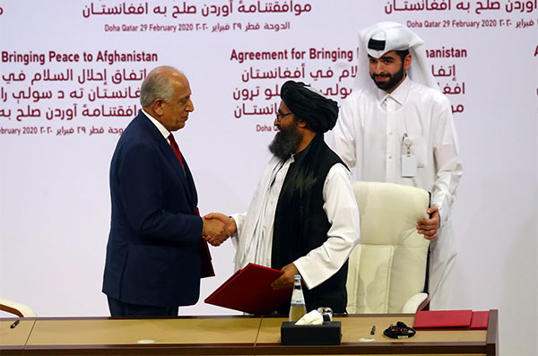 Đặc phái viên Mỹ Zalmay Khalilzad (trái) bắt tay với ông Mullah Abdul Ghani Baradar, lãnh đạo phái đoàn Taliban, sau khi ký thỏa thuận lịch sử tại Doha, Qatar ngày 29-2 - Ảnh: Reuters