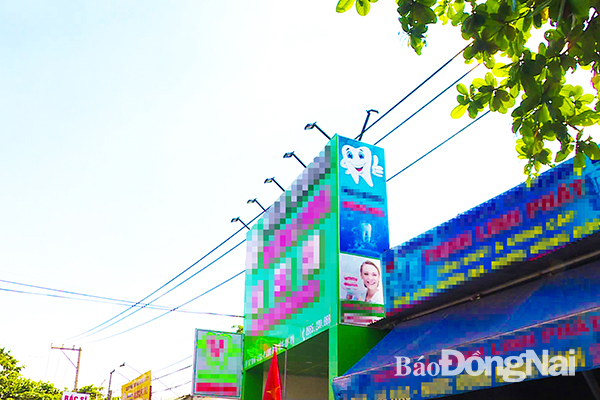 Một trường hợp lắp bảng quảng cáo vi phạm hành lang an toàn lưới điện cao áp tại P.An Bình (TP.Biên Hòa). Ảnh: Minh Thành