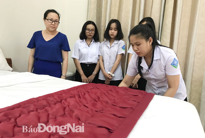 Em Trương Kim Ngân (bìa phải), học sinh nghề quản trị nhà hàng - khách sạn, Trường cao đẳng Nghề công nghệ cao Đồng Nai trong một tiết thực hành. Ảnh: H.YẾN