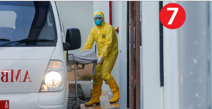 Nhân viên y tế kéo cáng chở bệnh nhân nhiễm Covid-19 từ xe cứu thương đến phòng cách ly tại Bệnh viện Sanglah ở Denpasar, Bali (Indonesia) ngày 11-3, ngày nước này có ca tử vong đầu tiên do Covid-19