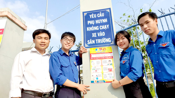 Đoàn viên, thanh niên H.Nhơn Trạch dán bảng thông tin phòng, chống dịch bệnh Covid-19 tại cổng trường học
