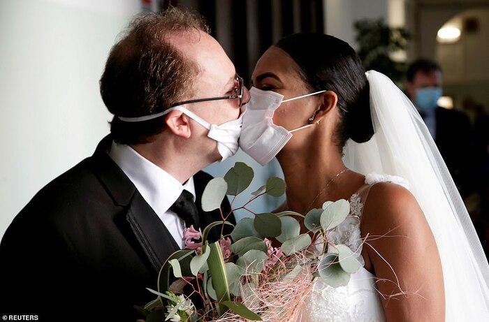 Đôi vợ chồng Diego Fernandes và Deni Salgado hôn nhau qua khẩu trang trong lễ cưới không khách mời của họ tại khu vực phong tỏa Naples (Italy) ngày 20-3. Ảnh: Reuters