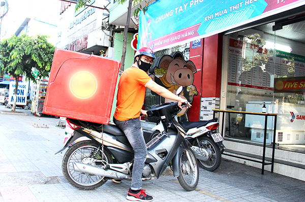Nhân viên chuẩn bị đi giao hàng của một cửa hàng thực phẩm trên đường Đồng Khởi (TP.Biên Hòa) cho khách