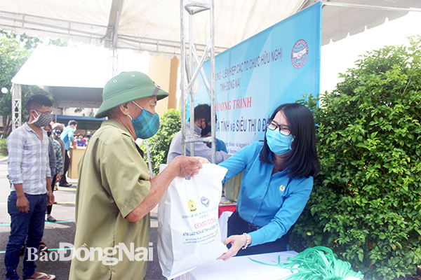 Chủ tịch Liên đoàn Lao động tỉnh Nguyễn Thị Như Ý giúp người lao động nhận gạo từ chương trình ATM gạo nghĩa tình được tổ chức tại Công đoàn Khu công nghiệp Biên Hòa