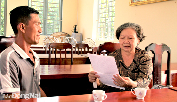 Bà Trần Kim Huê (ngụ ấp 6, xã Trà Cổ, H.Tân Phú) trao đổi cùng ban ấp về danh sách hộ khó khăn cần được hỗ trợ quà trong thời gian tới. Ảnh: V.Truyên