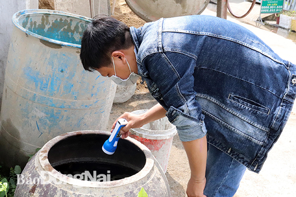 Nhân viên y tế giám sát muỗi, lăng quăng tại một hộ dân