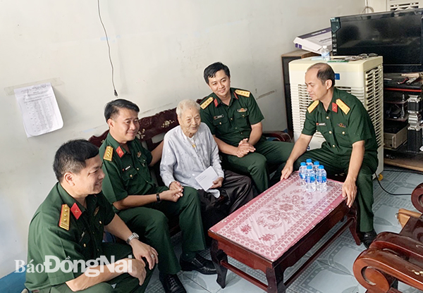 Thượng tá Nguyễn Tấn Linh (thứ hai từ trái qua) động viên, tặng quà mẹ Việt Nam anh hùng Nguyễn Thị Mùi