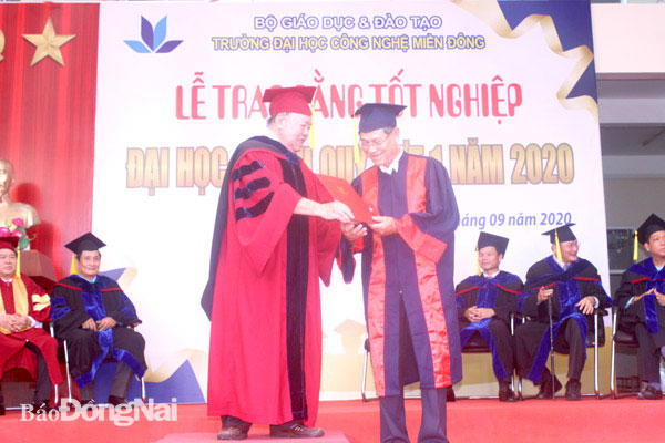 Hiệu trưởng Trường đại học Công nghệ miền Đông Huỳnh Văn Hoàng trao bằng tốt nghiệp đại học cho ông Võ Thanh Phong