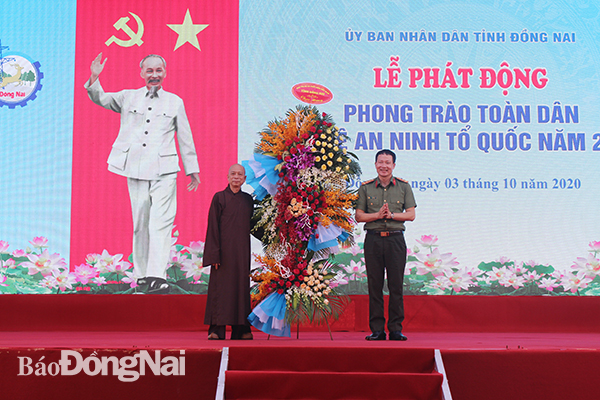  Đại diện ban tổ chức, đại tá Vũ Hồng Văn, Giám đốc Công an tỉnh nhận lẵng hỏa từ Thượng tọa Thích Huệ Khai, Phó ban Thường trực Ban trị sự Phật giáo tỉnh.