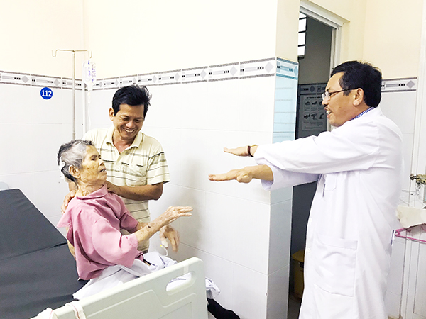 Giám đốc Bệnh viện Đa khoa khu vực Long Khánh Phan Văn Huyên xuống tận phòng bệnh hướng dẫn người nhà chăm sóc và tập vật lý trị liệu cho người bệnh