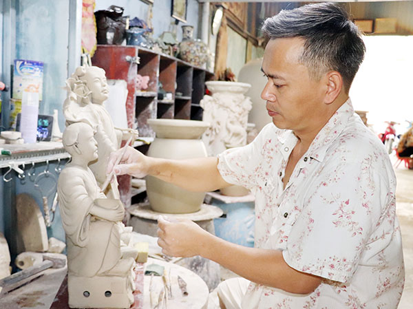 Nghệ nhân Hoàng Ngọc Hiến tạo hình cho tượng gốm