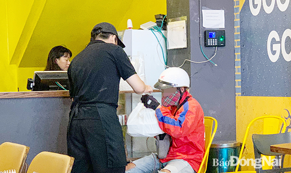 Một trong những nỗi lo lớn nhất của các shipper thức ăn nhanh là bị khách “bùng” hàng. Trong ảnh: Một shipper thức ăn nhanh ở TP.Biên Hòa mua hàng chuẩn bị giao cho khách. Ảnh: M.Thành