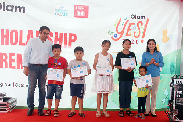 Đại diện lãnh đạo Công ty TNHH chế biến thực phẩm Olam Việt Nam - chi nhánh Long Thành và Liên đoàn Lao động huyện trao học bổng cho con công nhân. Ảnh: Lan Mai