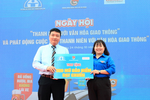  Đại diện Công ty Honda Việt Nam trao bảng tượng trưng 500 nón bảo hiểm cho đại diện Tỉnh đoàn