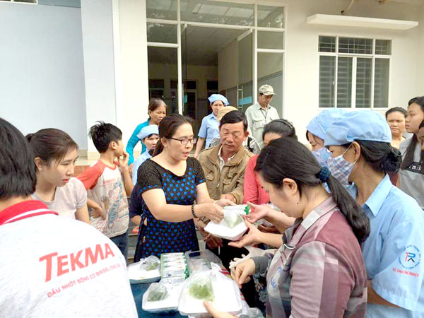 Chị Trương Thị Ngọc Hạnh (áo đen) trao tận tay những phần cơm cho người dân có hoàn cảnh khó khăn. Ảnh: Nhân vật cung cấp