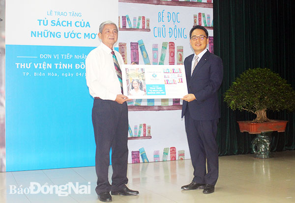Giám đốc khối chiến lược và kế hoạch Công ty Tài chính TNHH MTV Shinhan Việt Nam Yang Hyung Mo (phải) trao tặng sách cho Thư viện Đồng Nai
