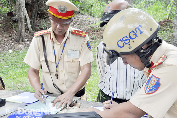 Lực lượng Cảnh sát giao thông Công an tỉnh lập biên bản xử lý một trường hợp vi phạm giao thông trên quốc lộ 20 đoạn qua H.Định Quán. Ảnh: Thanh Hải