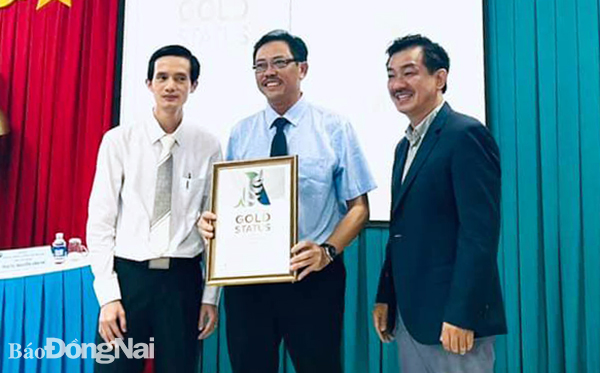 PGS-TS.Nguyễn Huy Thắng (bìa phải) tặng chứng nhận Gold của Hội Đột quỵ thế giới cho Giám đốc Bệnh viện Đa khoa khu vực Long Khánh Phan Văn Huyên