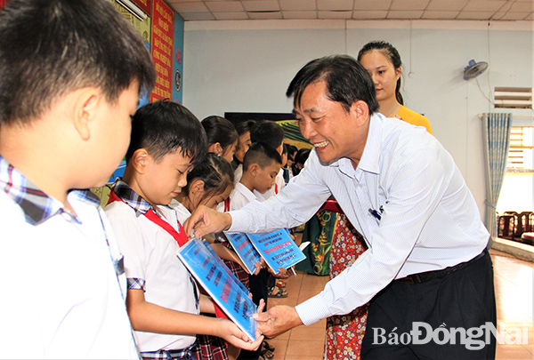 Ông Hoàng Văn Long, Giám đốc Quỹ Bảo trợ trẻ em tỉnh trao học bổng và quà cho học sinh có hoàn cảnh khó khăn tại H.Trảng Bom   
