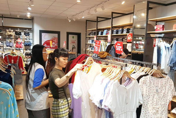Khách hàng chọn mua các sản phẩm khuyến mãi tại một cửa hàng thời trang trên đường Phạm Văn Thuận (TP.Biên Hòa) vào cuối tháng 11 vừa qua. (Ảnh: Hải Quân)