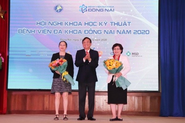 Giám đốc Bệnh viện Đa khoa Đồng Nai Ngô Đức Tuấn tặng hoa cho 2 bác sĩ ở TP.HCM tham dự hội nghị khoa học kỹ thuật của bệnh viện.