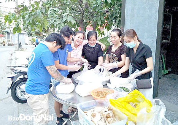 Những thành viên nhóm thiện nguyện Bạn và Tôi của chị Lê Thị Minh Hòa đang chuẩn bị đồ ăn để buổi tối đi phát cho người vô gia cư. Ảnh do nhóm Bạn và Tôi cung cấp