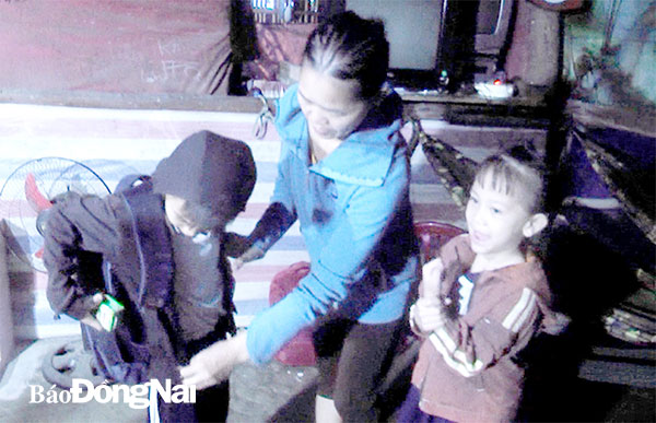 Chị Trịnh Nguyễn Đài Cát Phượng đang chuẩn bị sách vở cho 2  con xuống núi đi học từ sáng sớm. Ảnh: Hải Đình