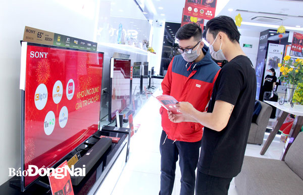 Người tiêu dùng tham khảo giá bán các sản phẩm tivi tại một trung tâm thương mại điện tử trên đường Phạm Văn Thuận, TP.Biên Hòa. Ảnh: Lam Phương