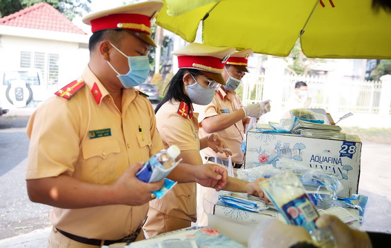 Trong buổi sáng 16-2 Phòng Cảnh sát giao thông tiếp tục tổ chức phát nước uống, khẩu trang, khăn lạnh miễn phí cho người đi đường trên các tuyến quốc lộ qua Đồng Nai