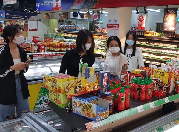 Người dân mua sắm tại siêu thị Vinmart ở Trung tâm thương mại Vincom Biên Hòa tuân thủ việc đeo khẩu trang phòng, chống dịch Covid-19. Ảnh chụp vào ngày mùng 5 Tết (ngày 16-2).