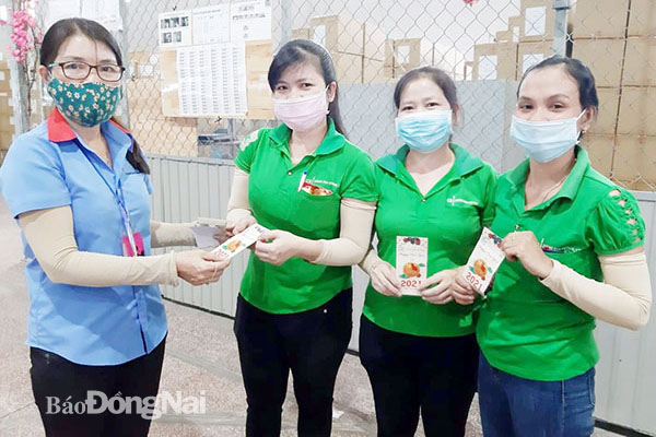 Đại diện Công ty TNHH Changshin Việt Nam (H.Vĩnh Cửu) lì xì đầu năm mới cho công nhân. Ảnh: N.HÒA