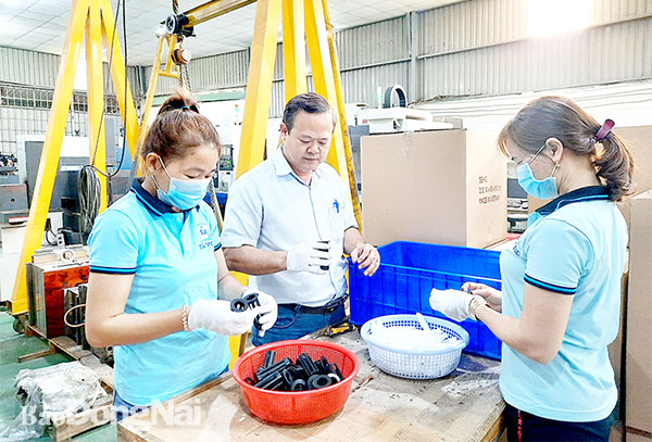 Chủ tịch Hội đồng thành viên Công ty TNHH Tân Seiko Nguyễn Văn Tân và công nhân kiểm tra sản phẩm nhựa kỹ thuật trước khi giao cho đối tác. Ảnh: Văn Gia
