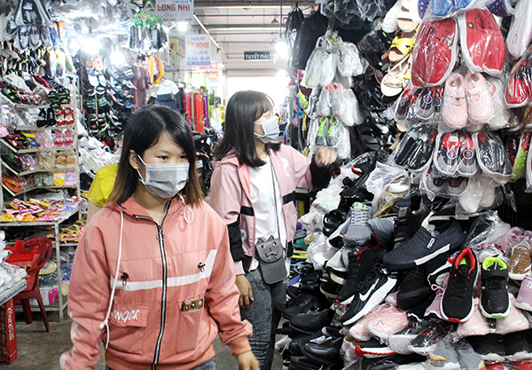 Người dân chọn mua các sản phẩm giày dép tại một sạp kinh doanh trong chợ Long Khánh (TP.Long Khánh)