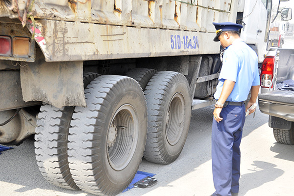 Lực lượng thanh tra giao thông dùng cân xách tay kiểm tra lưu động tải trọng xe tải ben trên quốc lộ 20 (đoạn qua H.Định Quán). Ảnh: V.NGUYÊN