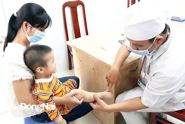 Bác sĩ Bệnh viện Nhi đồng Đồng Nai khám cho một trẻ mắc bệnh tay chân miệng. Ảnh: Hạnh Dung