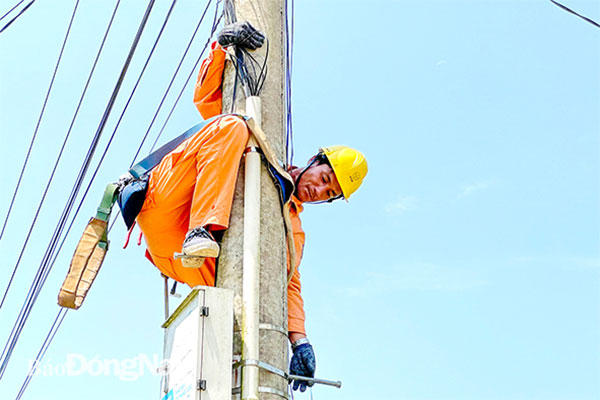Một trong những khó khăn trong công việc của thợ điện ở xã Đắc Lua (H.Tân Phú) là phải leo cao sửa điện giữa cánh đồng khi trời mưa gió. Ảnh: Đăng Tùng