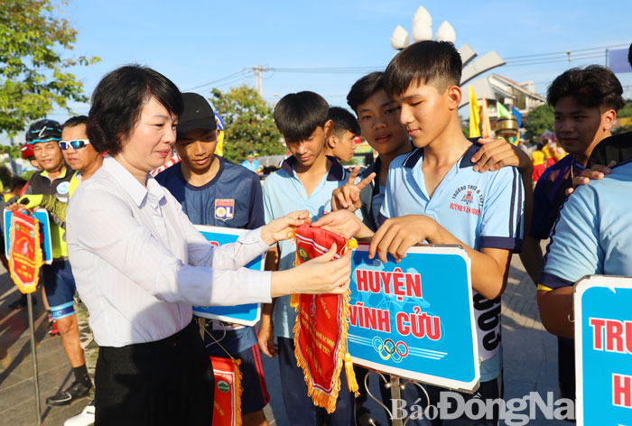 PHó chủ tịch UBND huyện Vĩnh Cửu Nguyễn Thị Dung tặng cờ lưu niệm cho các đơn vị tham dự lễ khai mạc