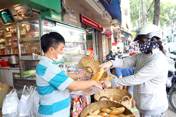 Khách mua bánh mì tại một tiệm trên đường Phan Đình Phùng, TP.Biên Hòa. Ảnh: Huy Anh