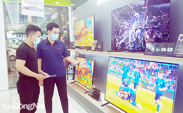 Người tiêu dùng tham khảo các mẫu tivi tại một cửa hàng trên đường Phạm Văn Thuận, TP.Biên Hòa. Ảnh: L.Phương