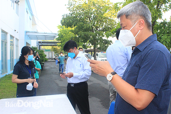 Thành viên đoàn kiểm tra thực hiện khai báo y tế trước khi vào Công ty TNHH Daikan Việt Nam, KCN Amata.