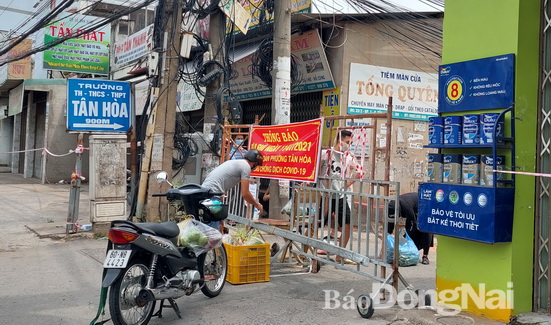 Người dân tiếp tế và nhận lương thực tại các chốt phong tỏa ở P.Tân Hòa, TP.Biên Hòa.