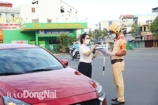 UBND tỉnh đã ban hành văn bản yêu cầu cán bộ, công chức, viên chức, người lao động phải đeo thẻ công chức, thẻ ngành kết hợp với giấy đi đường khi di chuyển ngoài cơ quan Trong ảnh: Lực lượng công an kiểm tra giấy tờ, thẻ công chức, thẻ ngành một người tham gia giao thông. Ảnh: HUY ANH