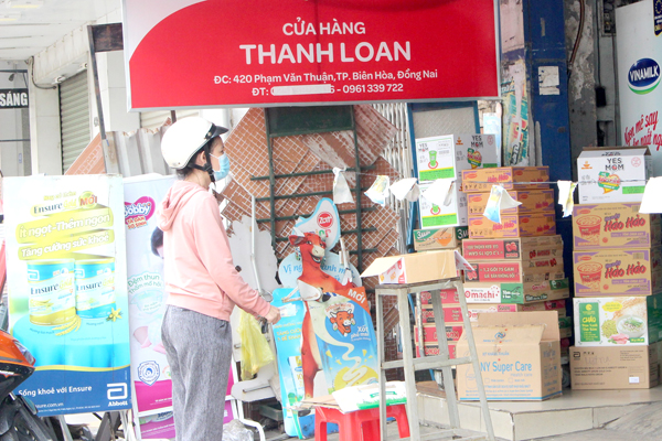 Một người dân đứng chờ mua hàng thiết yếu tại cửa hàng Thanh Loan, P.Tân Mai (TP.Biên Hòa)