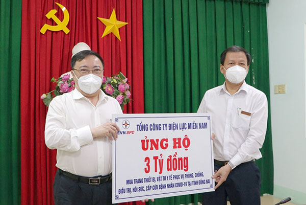 Ông Nguyễn Ngọc Thành, Chủ tịch kiêm Giám đốc Công ty Điện lực Đồng Nai (phải) trao tặng bảng biểu trưng số tiền 3 tỷ đồng cho lãnh đạo Sở Y tế Đồng Nai.